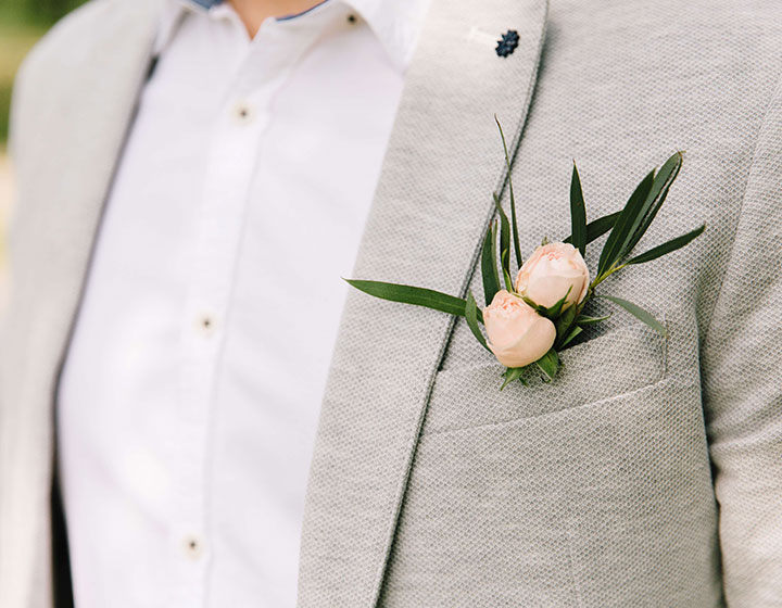man in gray suit with pink flower